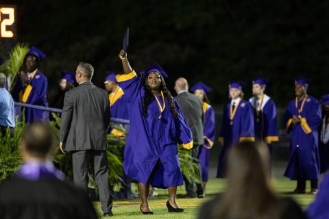 A graduate proudly holds up her diploma after walking off stage during commencement exercises Friday. (RAY CARPENTER/Special to the Reporter)