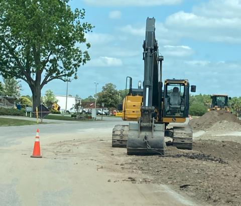 A City of Lake City contractor’s excavator is seen sitting on Ring Court without protection for the roadway. Work on the county road during a wastewater infrastructure project has Columbia County and Lake City officials bickering. (COURTESY)