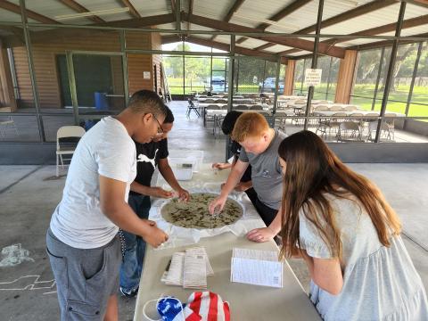 Richardson Catfish Club members look at plants, small fish and aquatic invertebrates in a ‘pour-a-pond’ at Alligator Lark Park. (COURTESY)