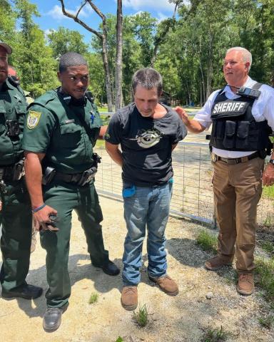 Daniel Scott Mobley Sr., center, was captured by the Suwannee County Sheriff’s Office on Thursday in the Three Rivers Estates following a tip to his location. Mobley is wanted for the armed robbery of a Dollar General on Tuesday. (COURTESY)
