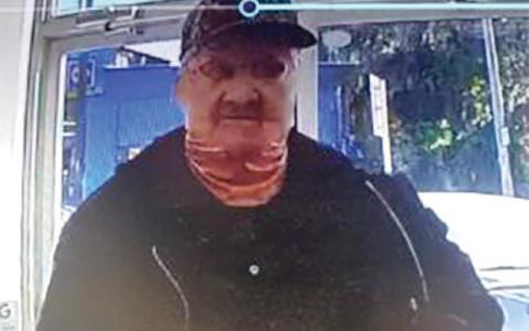 A still image from a North Florida Pharmacy surveillance  camera in Fort White shows the armed and masked man who robbed the store in January. (COURTESY)