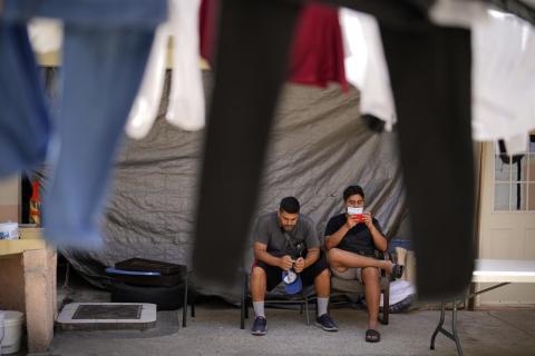 Two men from Nicaragua wait to apply for asylum in the United States Thursday, June 30, 2022, at a shelter for migrants in Tijuana, Mexico. (GREGORY BULL/Associated Press)