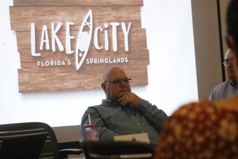 Rocky Ford, the chairman of the Columbia County Tourist Development Council, sits in front of the county’s new tourism logo, which includes the brand of ‘Lake City, Florida’s Springlands.’ (JAMIE WACHTER/Lake City Reporter)