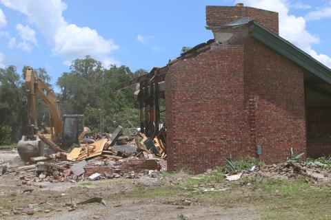 A building that formerly housed a Texas Roadhouse restaurant is torn down Tuesday afternoon. Demolition of the site began last week and is expected to be complete in the next few weeks. (TONY BRITT/Lake City Reporter)