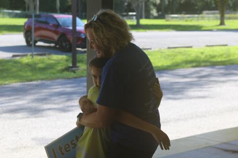 Dallas Douglass, 10, a fourth-grader at Columbia City Elementary School gets a hug from CCE third-grade teacher Jennifer Jordan on Monday afternoon. (TONY BRITT/Lake City Reporter)