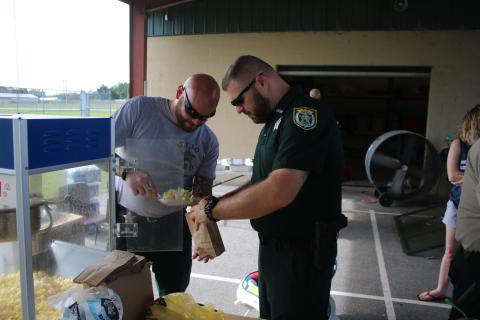 Columbia County Sheriff’s Office deputies Anthony Cortese and Mike Rodriguez bag up some popcorn at a ‘Summer Nights’ program last summer. (FILE)