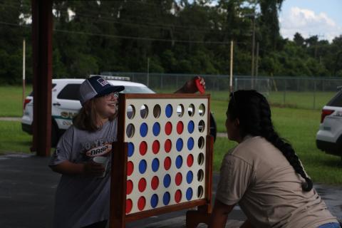 Keith Spence, 10, plays Connect Four with a Columbia County Sheriff’s Office school resource officer Friday during Summer Nights. (MORGAN MCMULLEN/Lake City Reporter)