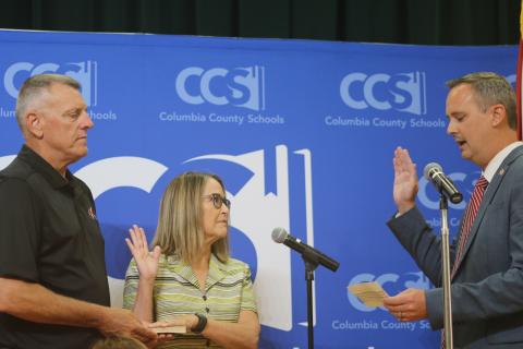 Columbia Clerk of Court Jay Swisher (right) swears in new school board member Cherie Hill ahead of Tuesday’s board meeting. (TONY BRITT/Lake City Reporter)
