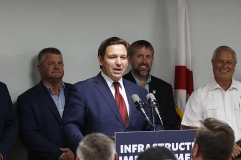 Florida Gov. Ron DeSantis awarded Suwannee County $1.9 million for water and wastewater improvements at its catalyst site during a press conference Tuesday. County Commissioners Franklin White (left) and Travis Land look on during the announcement. (JAMIE WACHTER/Lake City Reporter)