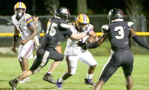 Columbia running back Tony Fulton tries to escape a tackle from Buchholz defensive end/linebacker Thomas Weinhardt on Thursday. (BRENT KUYKENDALL/Lake City Reporter)
