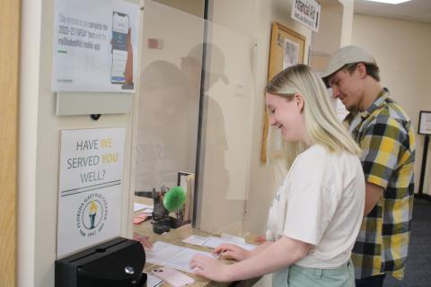 Bailey Lacy, of Lake City, gets help while at the Florida Gateway College financial aid office Monday as Kaiden Flint waits in line. FGC will begin classes for its 16-week fall semester on Monday, Aug. 22. (TONY BRITT/Lake City Reporter)