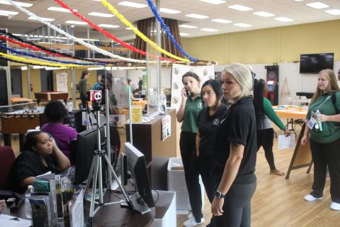 Amari Murphy (sitting) waits to take photographs for Florida Gateway College students as Kinsey Akins, Savannah Capps and Madisson Jones wait in line Monday afternoon. (TONY BRITT/Lake City Reporter)