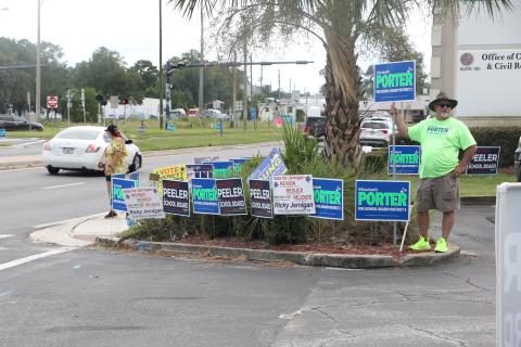 Volunteers for candidates stand outside the Columbia County Supervisor of Elections office in Lake City during the first week of early voting. (MORGAN MCMULLEN/Lake City Reporter)
