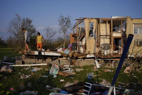 Aiden Locobon, left, and Rogelio Paredes look through the remnants of their family’s home destroyed by Hurricane Ida, Sept. 4, 2021, in Dulac, La. (JOHN LOCHER/AP File)