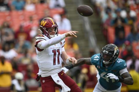 Washington Commanders quarterback Carson Wentz throws a pass as Jacksonville Jaguars linebacker Josh Allen chases after him during Sunday’s game in Landover, Md. (NICK WASS/Associated Press)