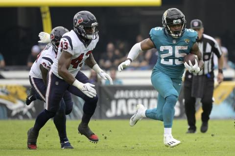 Jacksonville Jaguars running back James Robinson (25) runs past Houston Texans defensive tackle Jaleel Johnson (93) and middle linebacker Neville Hewitt (43) on Dec. 19, 2021, in Jacksonville. (AP FILE)