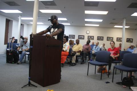Community activist Sylvester Warren reads off the reason for a ‘penalty flag’ being thrown against Councilman Todd Sampson during the Lake City Council meeting Monday evening. (TONY BRITT/Lake City Reporter)