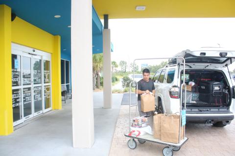 Long Vu, from Tampa, unpacks his vehicle at the Tru by Hilton hotel in Lake City as he evacuated due to threats from storm surge from Hurricane Ian. (TONY BRITT/Lake City Reporter)