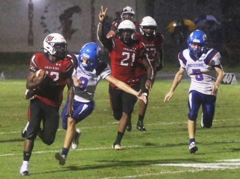 Fort White receiver Najeeb Smith rushes up the field ahead of Keystone Heights’ Wyatt Van zant on Friday. (MORGAN MCMULLEN/Lake City Reporter)