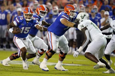 Florida quarterback Anthony Richardson (15) looks for running room as South Florida defensive end Eddie Kelly (16) looks to stop him during Saturday's game in Gainesville. (JOHN RAOUX/Associated Press)