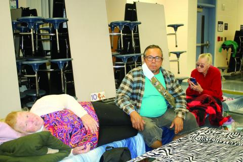 Rachel Orellana (from left), Cesar Aparicio and Mary Zrwalski, sit and unwind in the Pinemount Elementary School cafeteria that served as a Hurricane Ian shelter on Wednesday night. (TONY BRITT/Lake City Reporter)