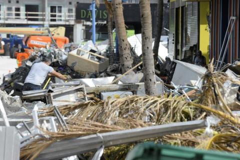 A man hauls debris away from a pizza restaurant that was badly damaged by Hurricane Ian at Fort Myers Beach on Sunday. (JAY REEVES/Associated Press)