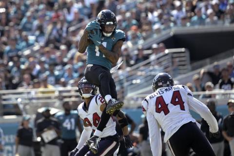 Jacksonville Jaguars wide receiver Marvin Jones Jr. catches the ball between Houston Texans cornerback Derek Stingley Jr. (24) and linebacker Jalen Reeves-Maybin (44) last Sunday in Jacksonville. (PHELAN M. EBENHACK/Associated Press)