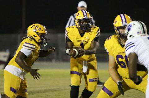 Columbia quarterback Tyler Jefferson hands the ball off against Ridgeview on Friday night. (BRENT KUYKENDALL/Lake City Reporter)