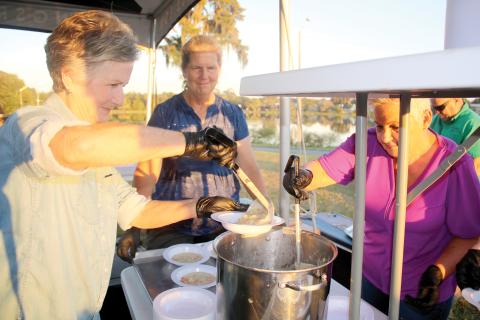 Emmie Chasteen (left) prepares a bowl of corn chowder Thursday evening during the Farm to Table event at Darby Pavilion. (TONY BRITT/Lake City Reporter)