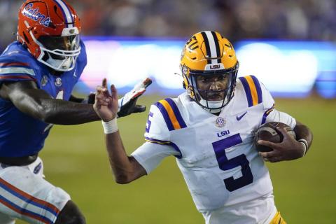 LSU quarterback Jayden Daniels slips by Florida linebacker Brenton Cox Jr. for a 9-yard touchdown run on Oct. 15 in Gainesville. (JOHN RAOUX/Associated Press)