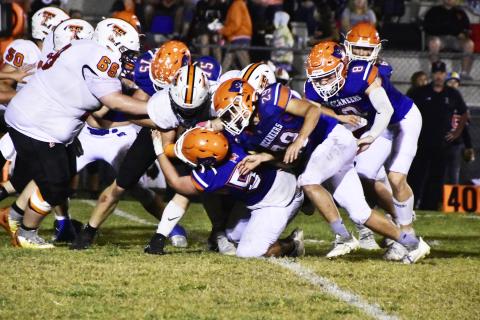 A host of Branford defenders, including Cole Certain (75), Ely Taylor (29) and Trevor Maddox (8) bring down a Trenton ballcarrier Friday. (ROB WOLFE/Special to the Reporter)