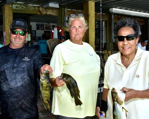 A trio of fishers display their catches at the eighth annual Hooked on Heroes fishing event. (ROB WOLFE/Special to the Reporter)