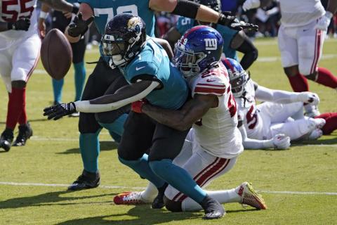 Jacksonville Jaguars running back Travis Etienne fumbles when he gets hit by New York Giants safety Xavier McKinney during Sunday's game in Jacksonville. (JOHN RAOUX/Associated Press)