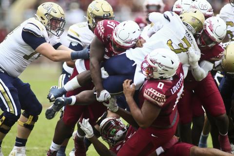 Florida State defenders, including defensive tackle Fabien Lovett (0), lift Georgia Tech running back Hassan Hall (3) off the ground as he tries to runs the ball on Saturday in Tallahassee. (PHIL SEARS/Associated Press)