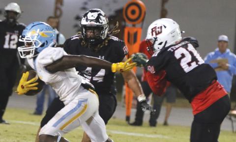 Chiefland running back Dakota Fisher (left) evades a tackle from Fort White’s Kamarion Griffin (44) and Darren Yates (44) on Friday. (MORGAN MCMULLEN/Lake City Reporter)