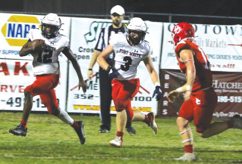 Fort White running back Najeeb Smith (12) rushes up the field as fullback Hayden Adams (3) looks to block against Dixie County last Friday night. (MORGAN MCMULLEN/Lake City Reporter)