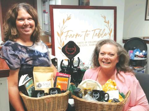 Lake City Community Program Manager Terri Phillips (left), and Kimi Roberts hold vendor baskets promoting the upcoming inaugural Farm To Table, A Taste of Columbia, Lake City, Florida event, which will take place 6:30 p.m. Thursday at Darby Pavilion. (TONY BRITT/Lake City Reporter)