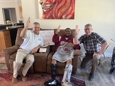 Columbia Schools Superintendent Lex Carswell (from left), Ricky Jernigan Jr. and CCS Assistant Superintendent  Todd Widergren give a tomahawk chop at Jernigan’s house after Jernigan received a letter and gifts from Florida State University football coach Mike Norvell. (COURTESY)
