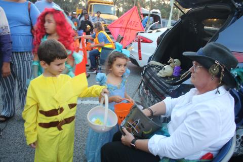 Omar Orta (from left), 4, and Adeline Garcia, 4, get candy from DOT employee Karen Williams on Monday evening at the inaugural FDOT Trunk or Treat event. (TONY BRITT/Lake City Reporter)