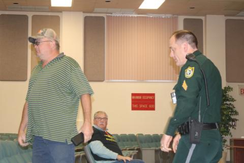 Derek Snead is escorted out of Thursday’s Columbia County Commission meeting by a Columbia County Sheriff’s deputy after outbursts that cut off Board Chairman Robby Hollingsworth. (TONY BRITT/Lake City Reporter)