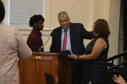 Fort White High School senior Khambrell White (left) is presented a certificate of appreciation by Columbia Schools Superintendent Lex Carswell (middle) and Columbia School Board Chair Narrie Smith on Monday for his actions in helping reunite a dementia patient with her family. (MORGAN MCMULLEN/Lake City Reporter)
