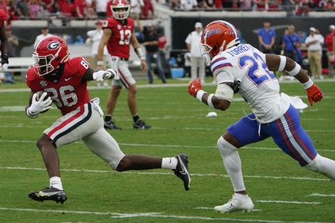 Georgia wide receiver Dillon Bell runs past Florida cornerback Jaydon Hill for yardage after a reception during Saturday's game in Jacksonville. (JOHN RAOUX/Associated Press)