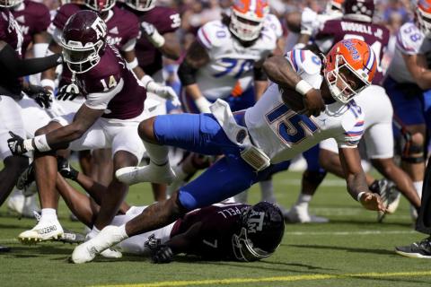 Florida quarterback Anthony Richardson dives past Texas A&M defensive back Jacoby Mathews for a touchdown on Saturday in College Station, Texas. (SAM CRAFT/Associated Press)