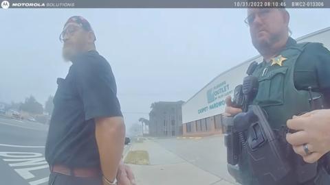 James Hodges (left) is placed in handcuffs in this still from body camera footage taken on Oct. 31. (COURTESY)
