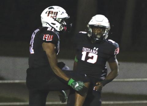 Fort White running back Najeeb Smith (12) celebrates with teammate Kamarion Griffin after scoring a touchdown against Santa Fe last Friday. (MORGAN MCMULLEN/Lake City Reporter)