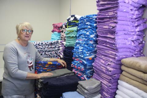 Meally Jenkins, the founder and director of the Christmas Dream Machine, looks over the towels that have been donated to the organization. (TONY BRITT/Lake City Reporter)