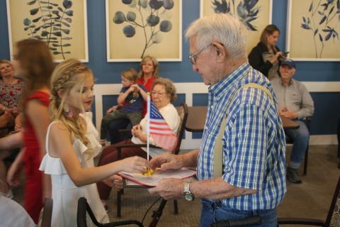 Jocelyn Jenkins (left), 12, presents John Cruise, an Army veteran, with a desk flag during a veterans recognition award ceremony at The Canopy. (TONY BRITT/Lake City Reporter)
