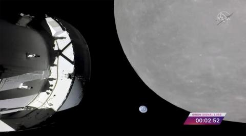 This screengrab from NASA TV shows NASA’s Orion capsule, left, nearing the moon Monday. At center is earth. (NASA via AP)
