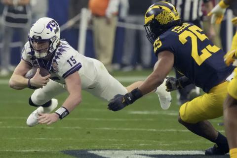 TCU quarterback Max Duggan (15) dives for yardage as Michigan linebacker Junior Colson (25) defends the Fiesta Bowl playoff semifinal on Saturday in Glendale, Ariz. (RICK SCUTERI/Associated Press)