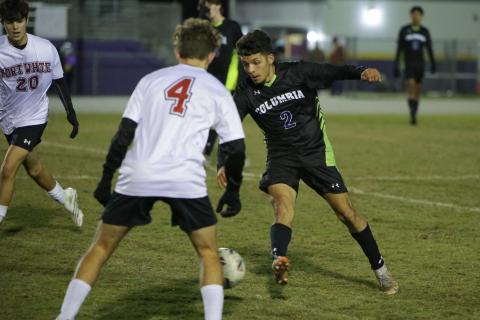 Columbia’s Jason Caballero dribbles up the field against Fort White’s Gavin Heaton on Monday night. (BRENT KUYKENDALL/Lake City Reporter)